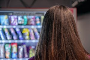 Rear view of woman by vending machine